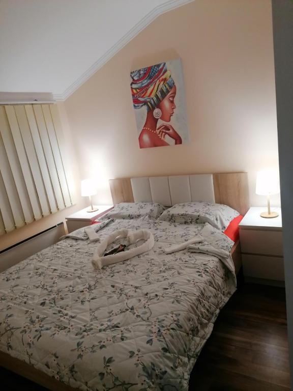 una camera da letto con un letto con due lampade sopra di Apartman Dionis SM a Sremska Mitrovica