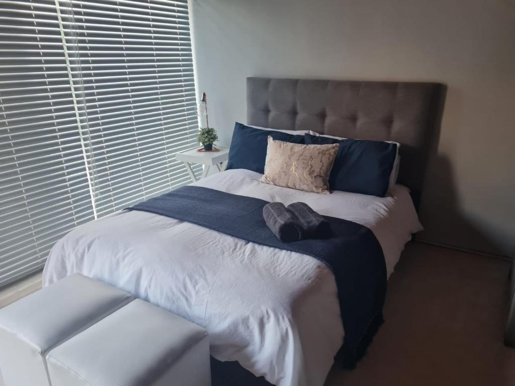Un pat sau paturi într-o cameră la La Maison Kuilsrivier