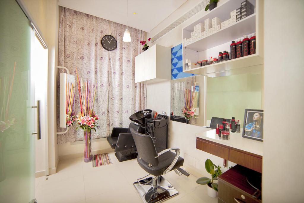a hair salon with a chair and a desk at Raviz Center Point Hotel in Dubai