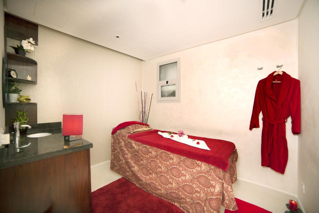 a room with a bed and a robe hanging on a wall at Raviz Center Point Hotel in Dubai