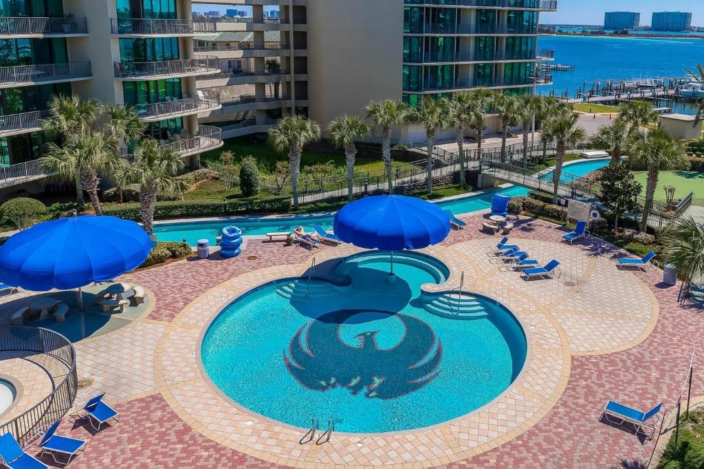 una vista aérea de una piscina con sombrillas azules en Phoenix on the Bay by Brett Robinson Vacations, en Orange Beach