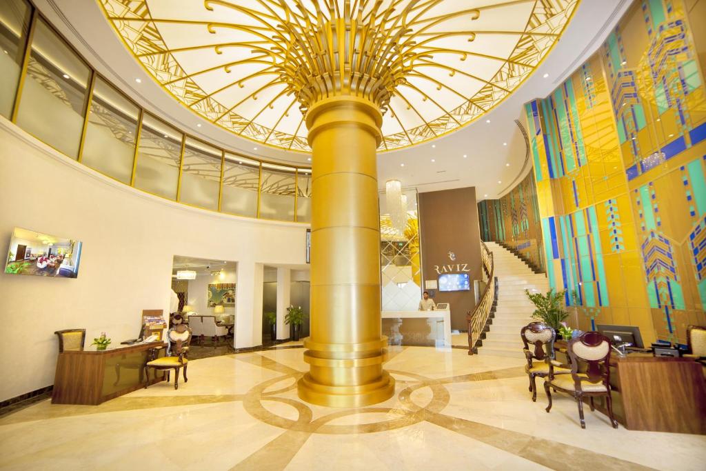 a large gold column in the middle of a lobby at Raviz Center Point Hotel in Dubai