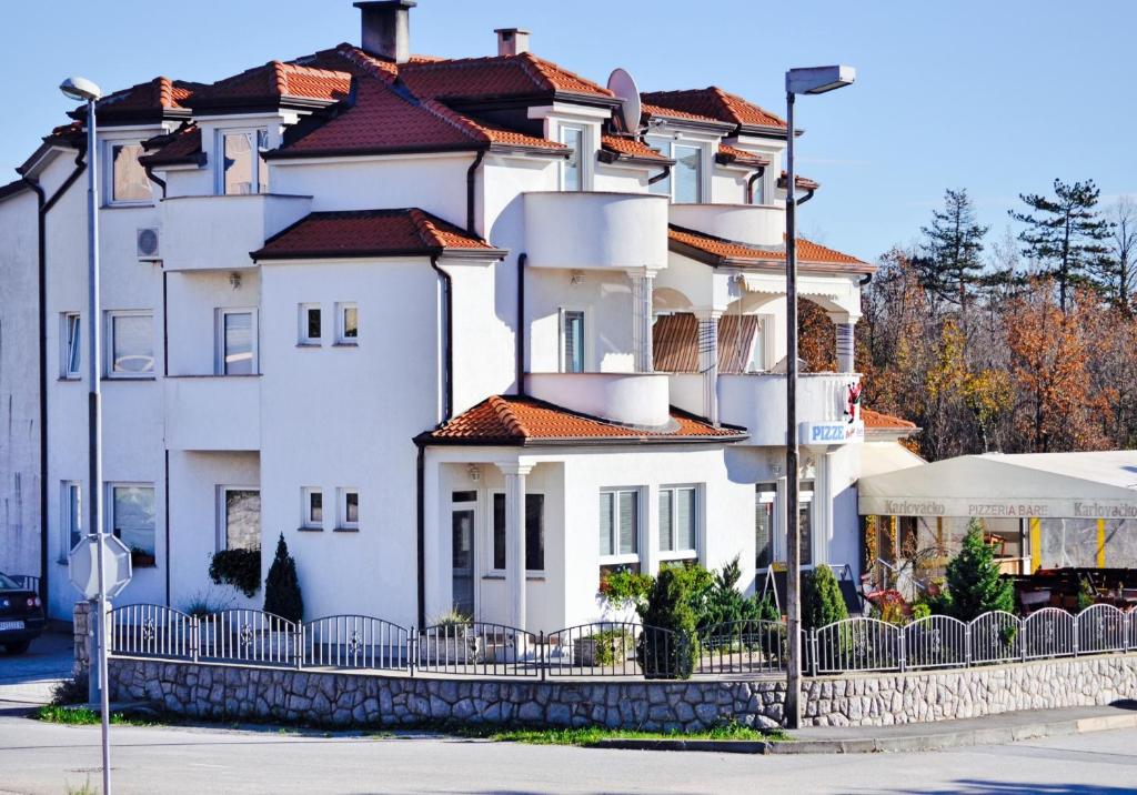 una casa blanca con una valla delante en Apartments Villa Bare en Kastav