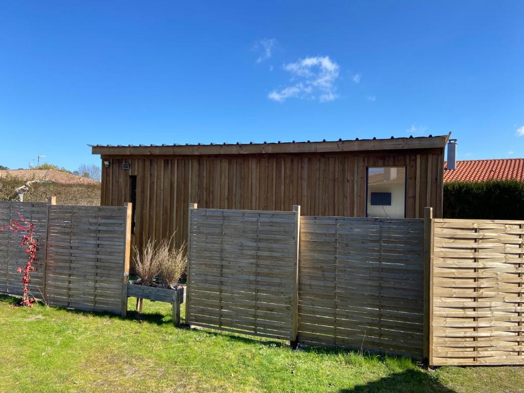 a wooden fence in front of a house at Gîte Lauraët in Linxe