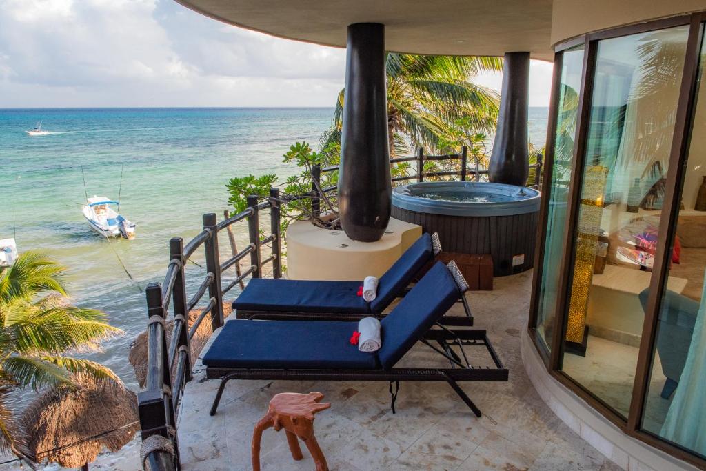 two blue lounge chairs on a balcony overlooking the ocean at El Taj Oceanfront and Beachside Condo Hotel in Playa del Carmen