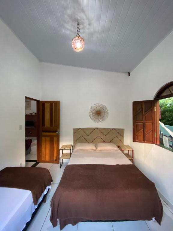 sypialnia z 2 łóżkami i oknem w obiekcie Terra Hostel e Pousada w mieście Lençóis
