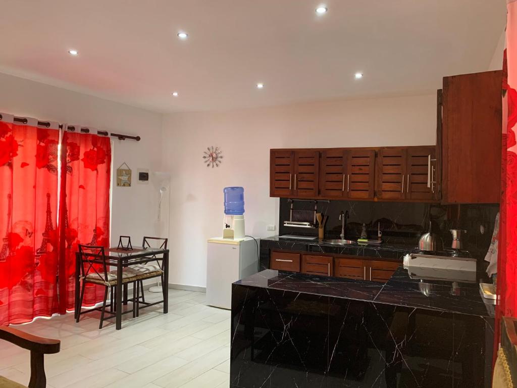 a kitchen with red curtains and a table in it at Villa Kate in Las Terrenas