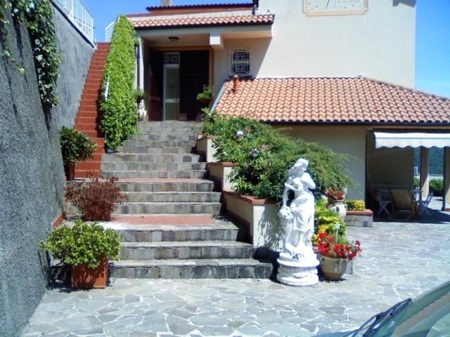 a statue sitting in front of a house with stairs at Affittacamere Le Meridiane in Maissana