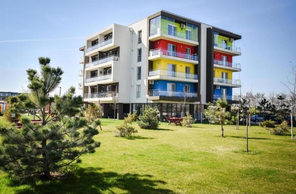 un edificio alto con ventanas coloridas en un parque en Tranzzit Airport Apartment II, en Otopeni
