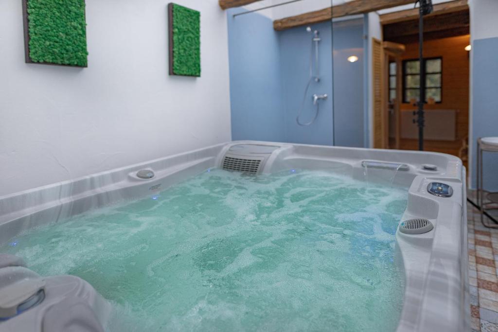 a bath tub filled with water in a bathroom at Kégli apartmanok és fürdőház Hollókő in Hollókő