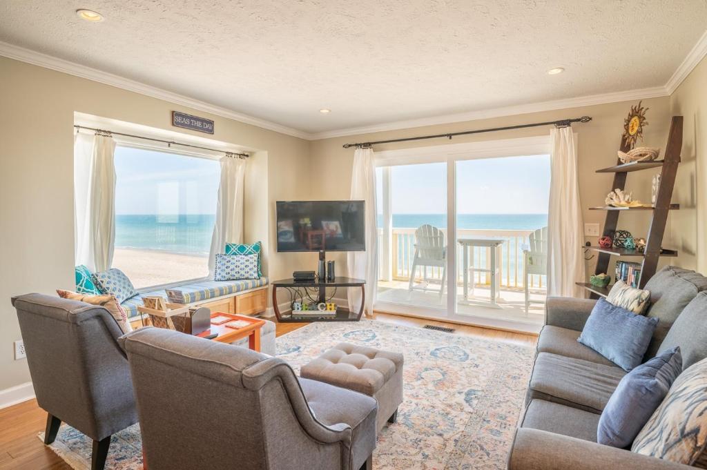 a living room with a view of the ocean at Oceanfront Condo with 3+ Pools - Ocean Dunes 1701 in Kure Beach