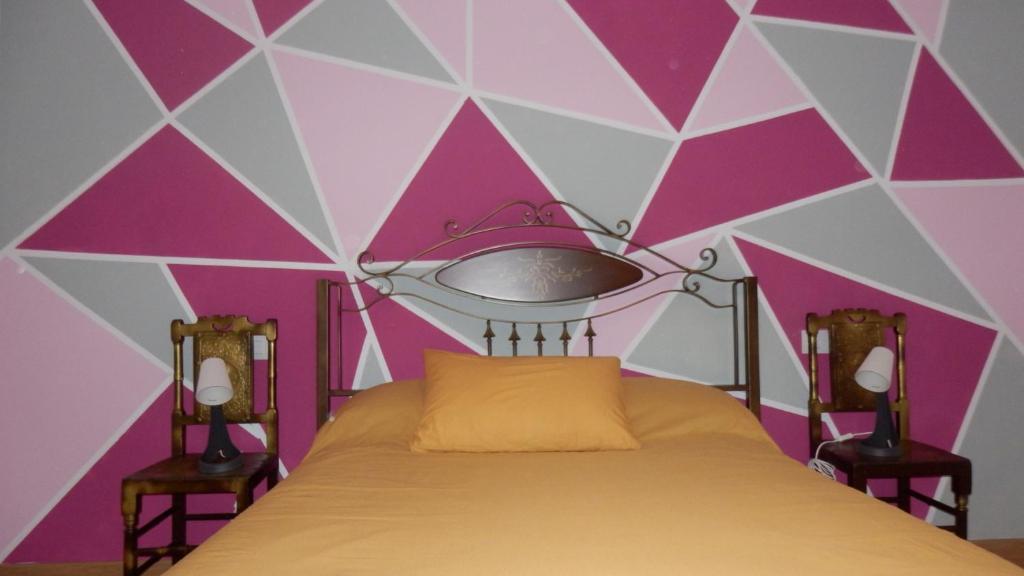 1 dormitorio con 1 cama en una pared de color rosa y blanco en THE QUEEN, en Arcas