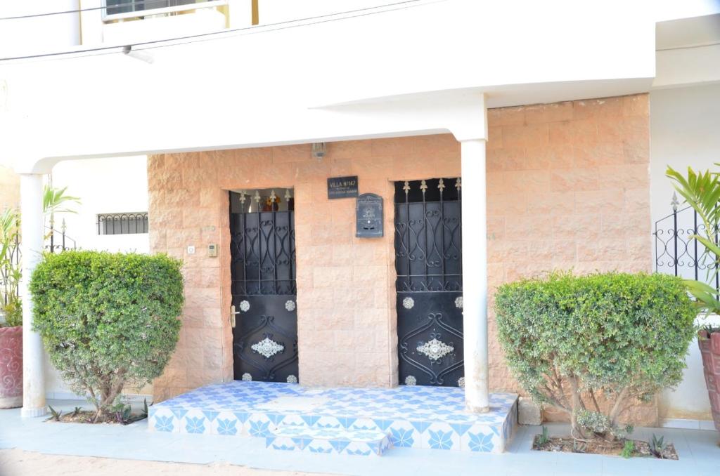 a house with a blue and white mattress in front of a black door at Appartement Luxueux in Dakar