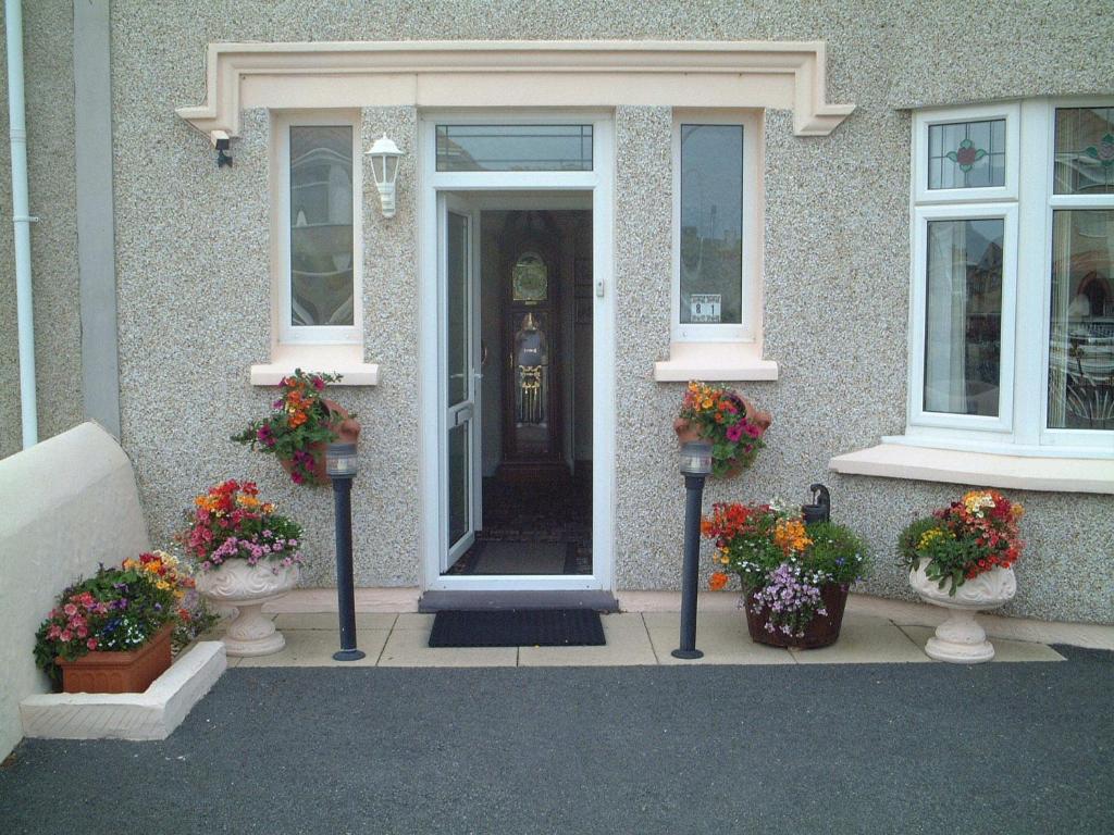 a front door of a house with vases of flowers at Crossroads in Holyhead