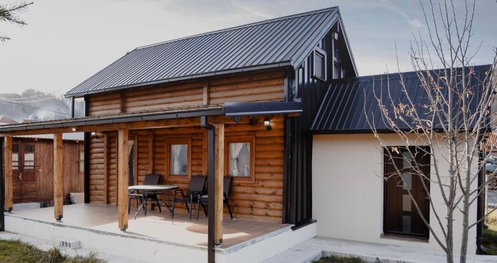 a cabin with a black roof and a table on a deck at Rustic house in Kolašin