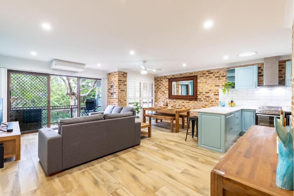 a large living room with a couch and a kitchen at Bay Parklands, 36 2 Gowrie Avenue - close to the water with Air con, WiFi, pool & spa & tennis court in Shoal Bay