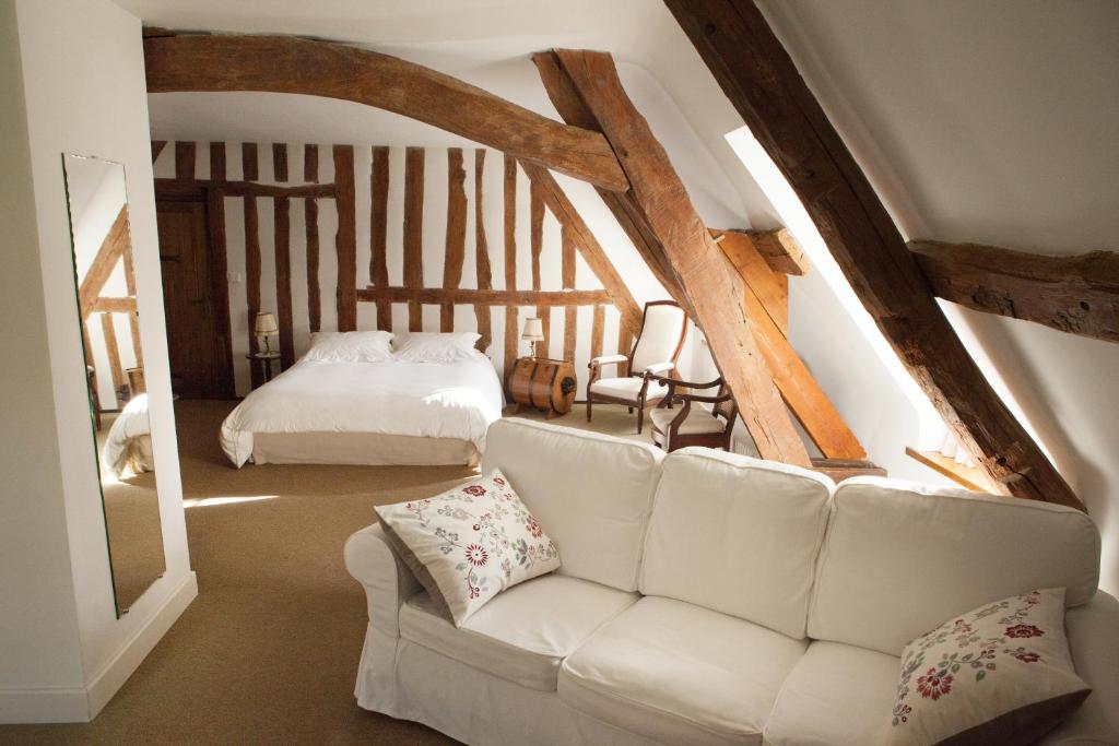 a living room with a white couch and a bed at A la Bergerie in Honfleur