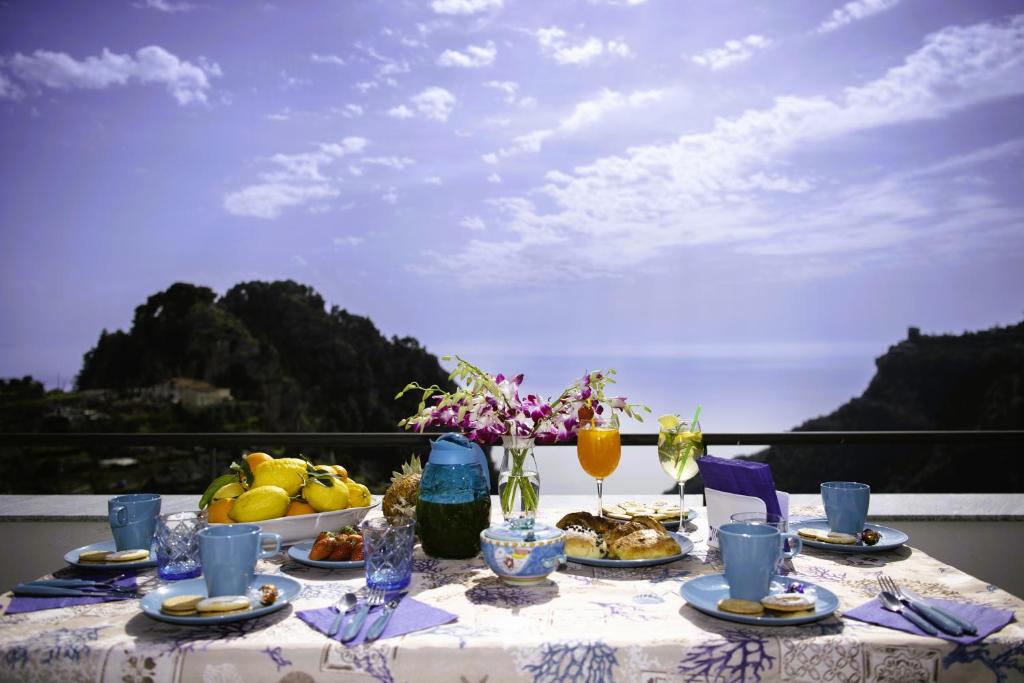 una mesa con comida y bebida en el balcón en Amalfi Sea View en Scala