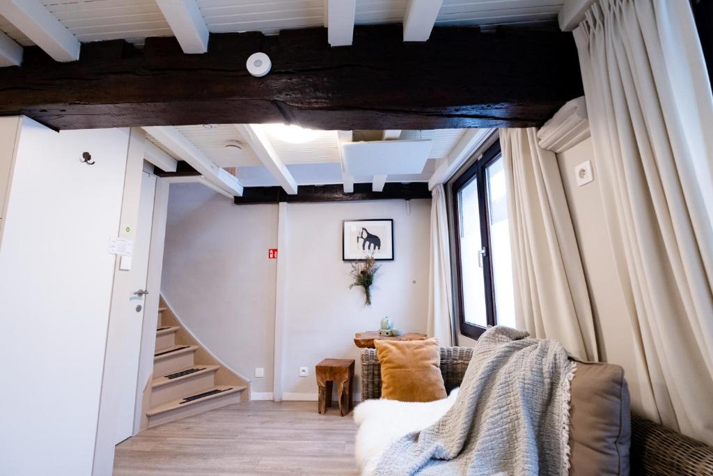 sala de estar con escalera y sofá en Cityhome Apartments in the heart of Antwerp, en Amberes