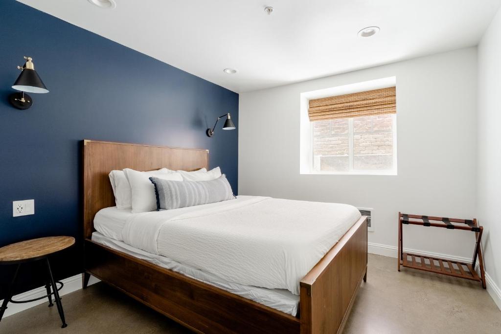 1 dormitorio con 1 cama grande y pared azul en The World's Fair Home, en Portland