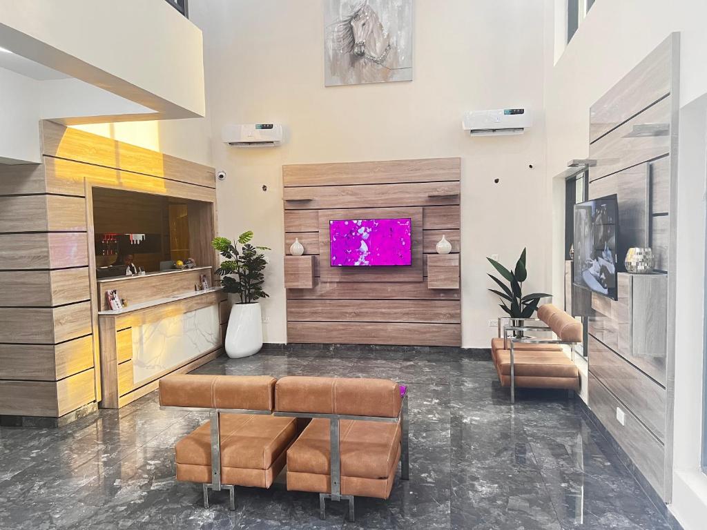 a living room with a tv on a wall at De Rigg Place Embassy in Lagos
