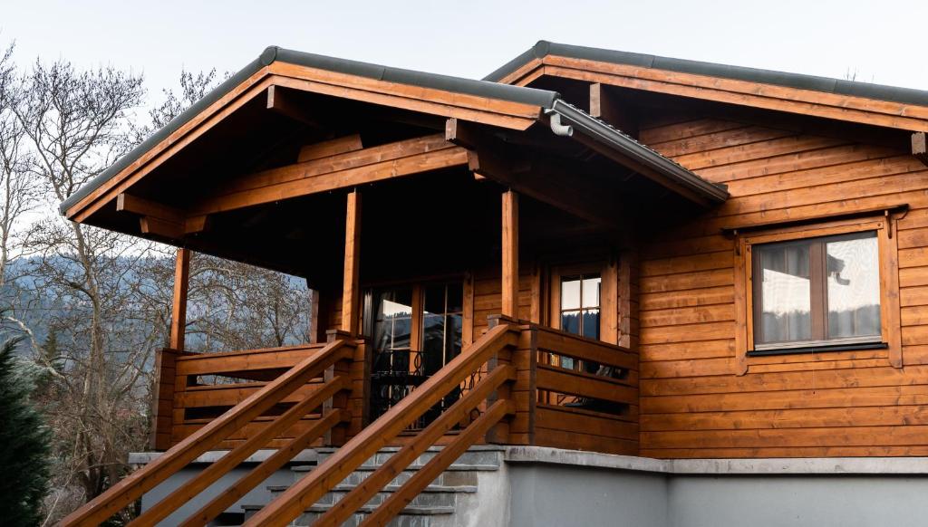 eine Blockhütte mit einer Veranda und einer Terrasse in der Unterkunft Riverside Forest Retreat-Chalet in Karpenisi