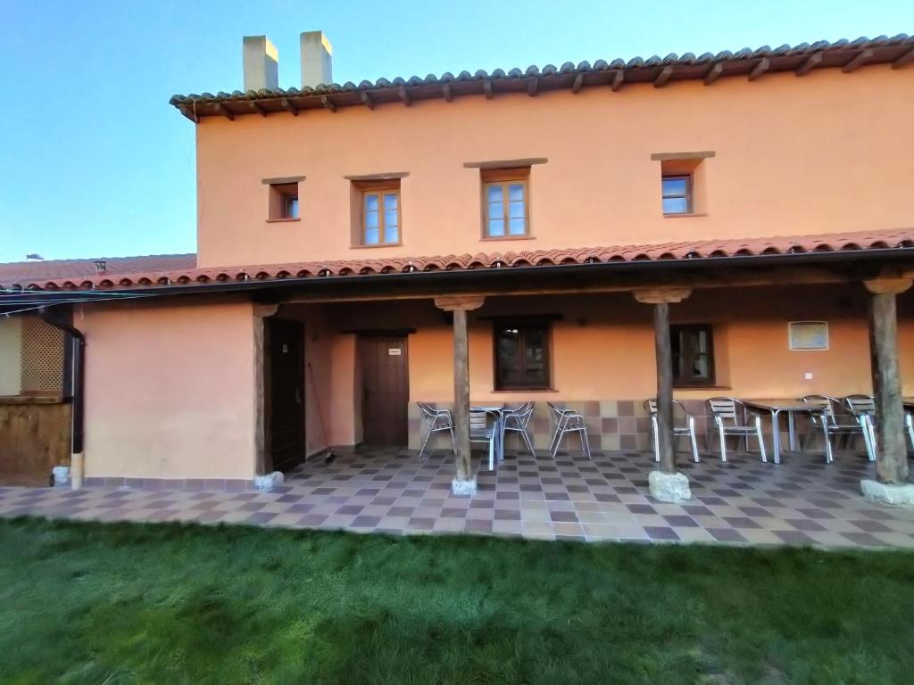 d'une terrasse en face d'une maison avec des tables et des chaises. dans l'établissement Don Camino Low Cost, à Villalcázar de Sirga