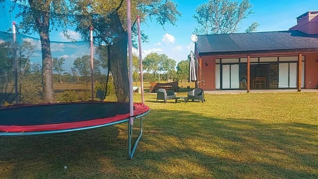a swing in a yard next to a house at Casa con pileta en Paso de la Patria in Paso de la Patria