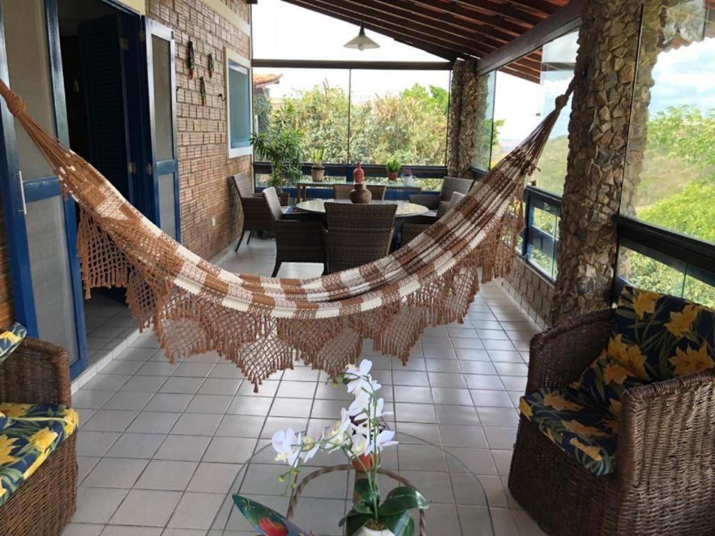 a hammock on the porch of a house at Casa Cantinho da Paz, seu lazer completo, churrasqueira, piscina e muita tranquilidade in Gravatá