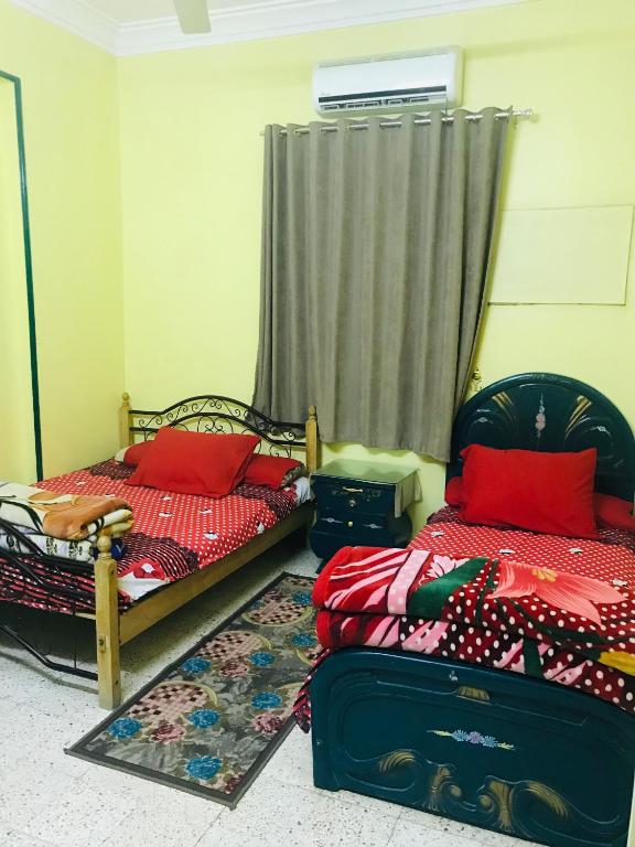 a bedroom with two beds and a suitcase at Gamal Robob Nubian Guest House in Aswan