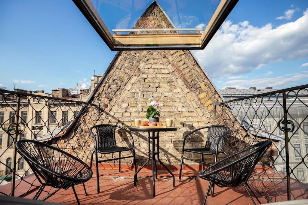 a patio with chairs and a table on a balcony at Luxury apartment in Gediminas avenue with terrace in Vilnius