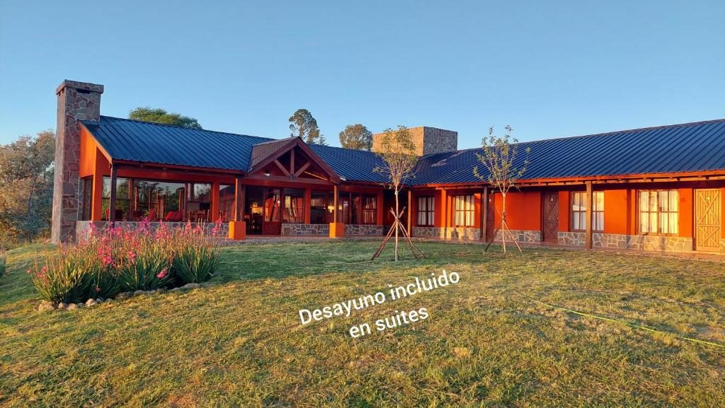 una casa con un gran patio delante de ella en CEDRO AZUL - Hostería y Cabañas de montaña en Villa Yacanto