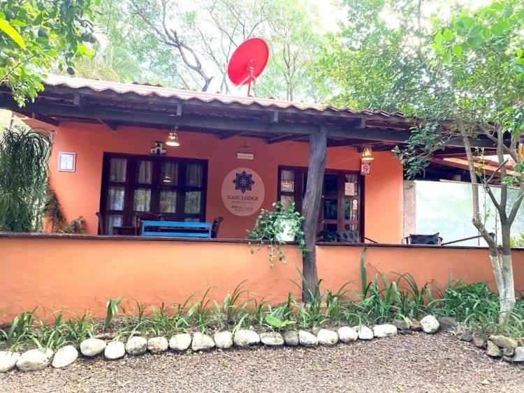 Nasu Lodge في لا كروز: منزل برتقالي صغير مع علامة حمراء عليه