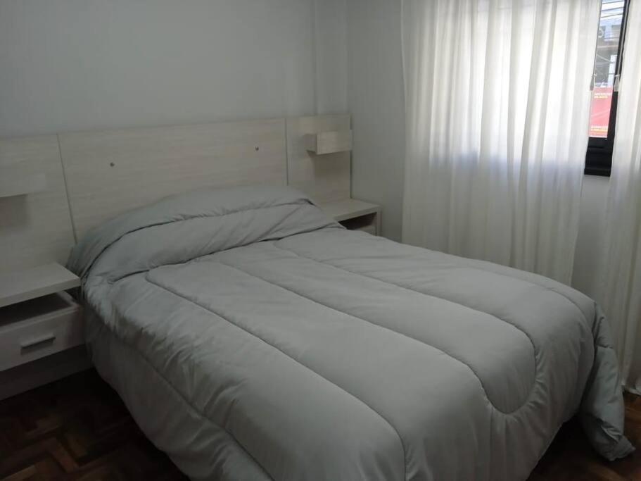 1 cama blanca en un dormitorio con ventana en Único Depto en Once en Buenos Aires