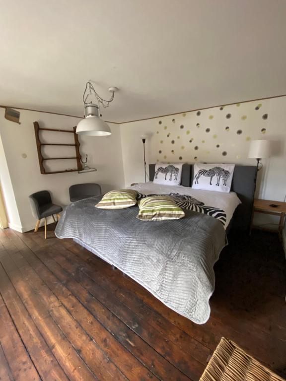 een slaapkamer met een groot bed met 2 kussens bij House in Eislek, North Luxembourg, dating from 1890, newly renovated 
