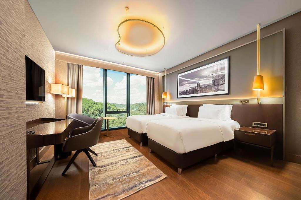 a hotel room with a bed and a desk and a desk at Radisson Collection Hotel, Vadistanbul in Istanbul