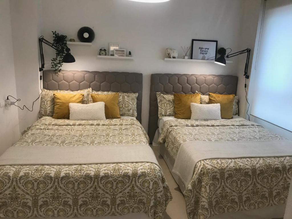 2 camas en un dormitorio con almohadas amarillas en Designer's Flat - 3 Bdrm - Wifi - Best Location, en Alicante