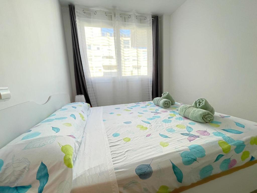 ein Schlafzimmer mit einem Bett mit zwei ausgestopften Tieren darauf in der Unterkunft Apartamentos Novacala Benidorm in Cala de Finestrat