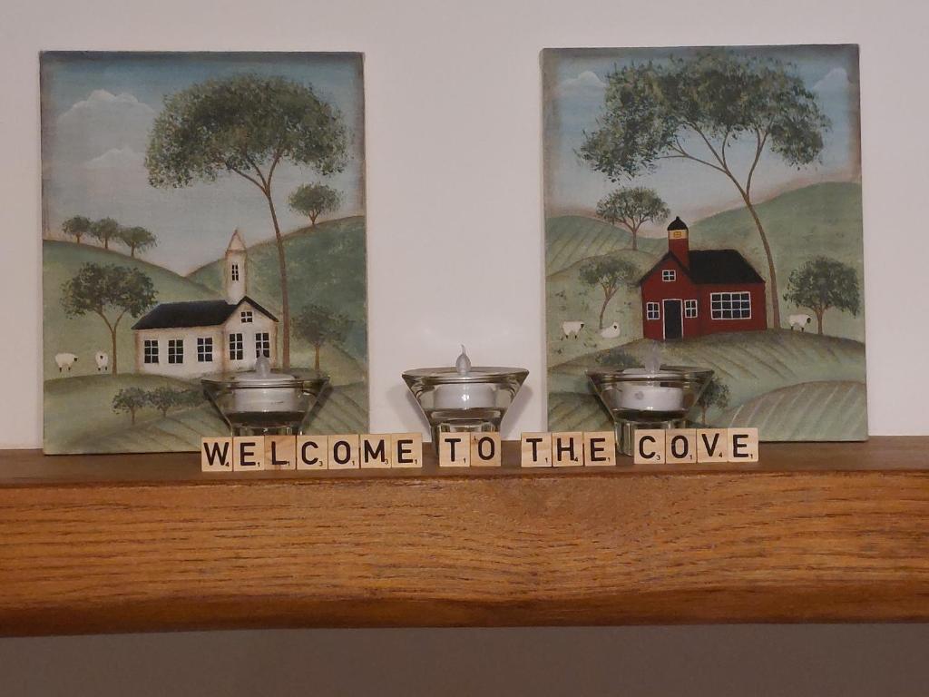 a wooden shelf with three pictures and a welcome to the cave at The Cove in Aughnacloy