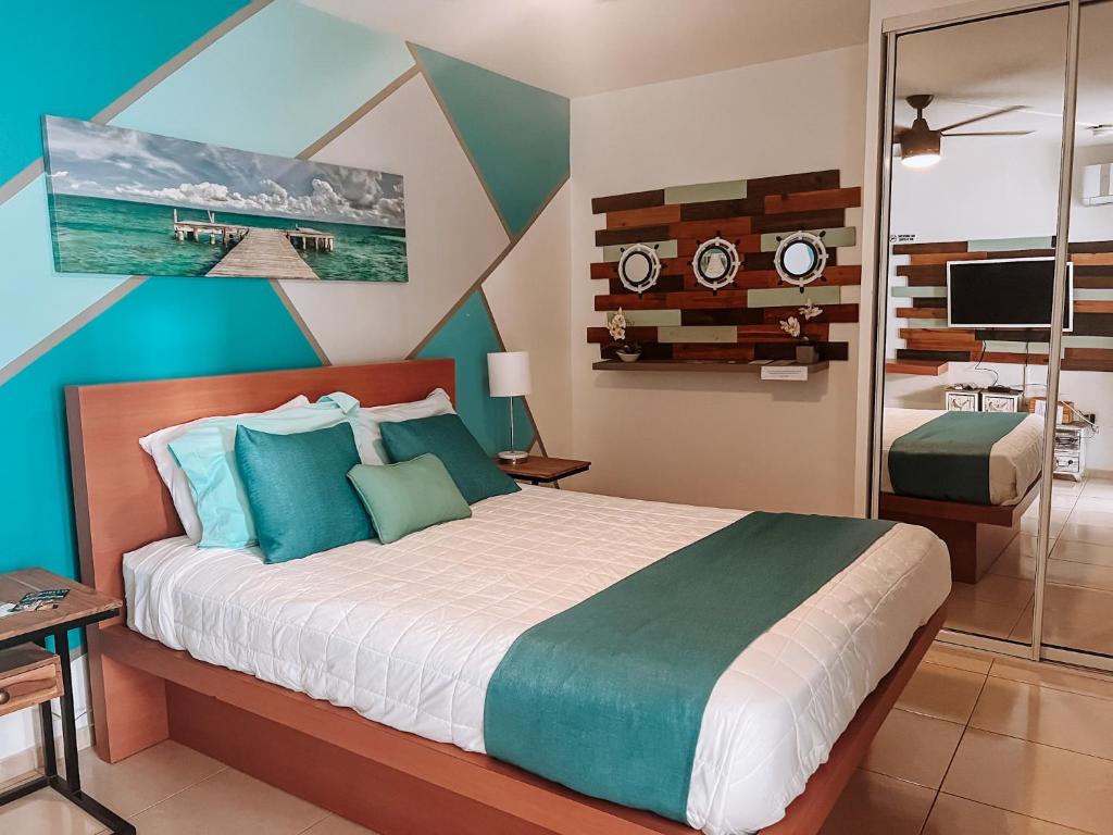 a bedroom with a bed with blue and green at Aqua Marina Beach Club in Rincon