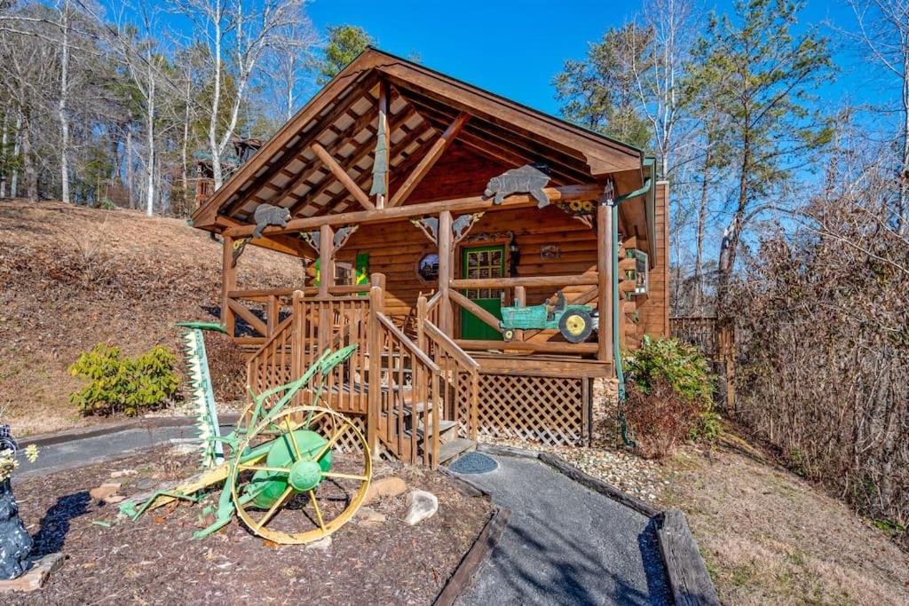 a wooden cabin with a playground in the woods at The Mountain Farmer in Sevierville