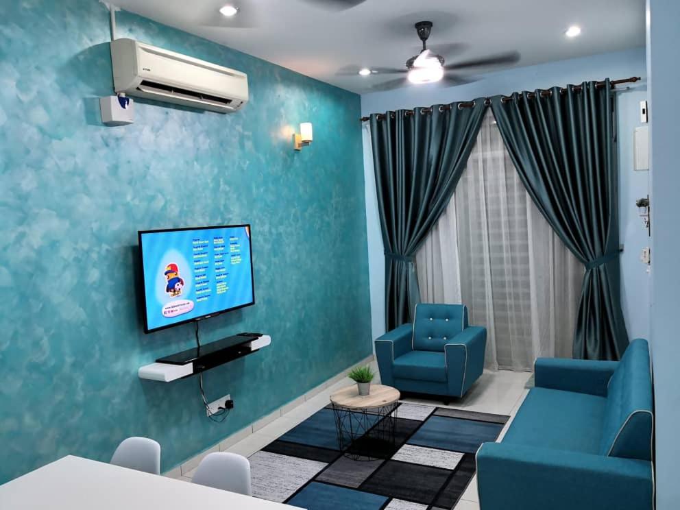 een woonkamer met een tv en een blauwe muur bij MIZU Homestay Melaka in Melaka