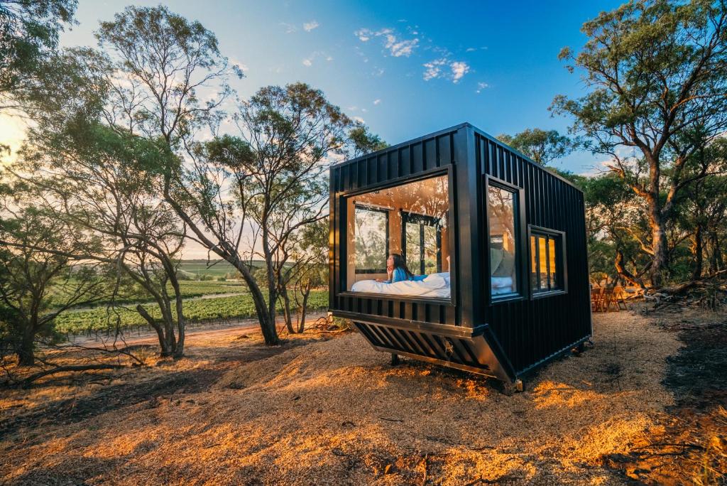 a person is sitting in a black tiny house at CABN Off Grid Cabins Barossa in Seppeltsfield