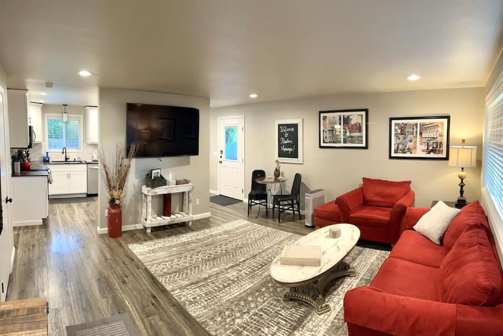 a living room with a red couch and a table at Beautiful, well-stocked home - sleeps 7! in Yakima