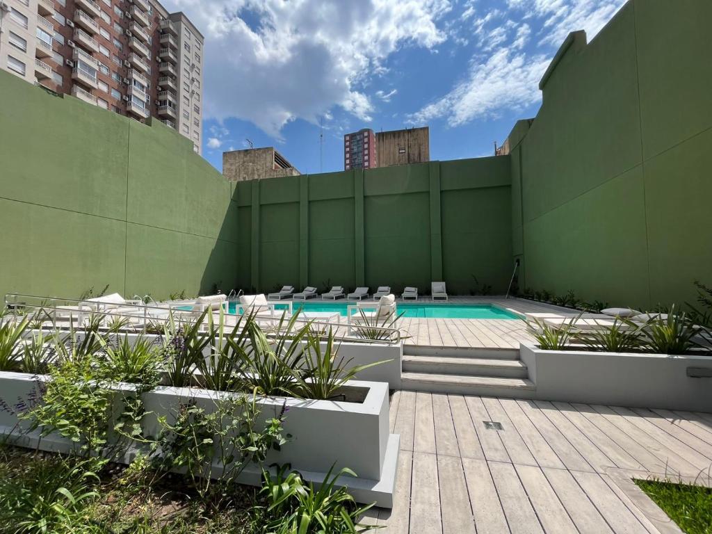 una piscina con sillas y una pared verde en Boreas Tango en Buenos Aires