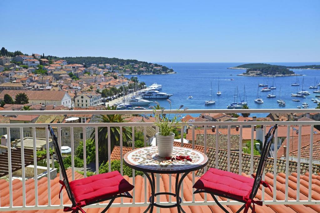 een tafel en stoelen op een balkon met uitzicht op het water bij Apartments and Rooms Bonkan Hvar in Hvar