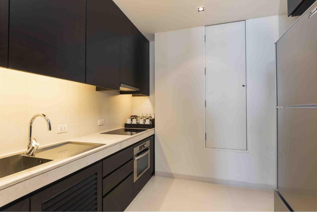 A fitted kitchenette has a sink, cooktop, oven and tall storage cabinets.