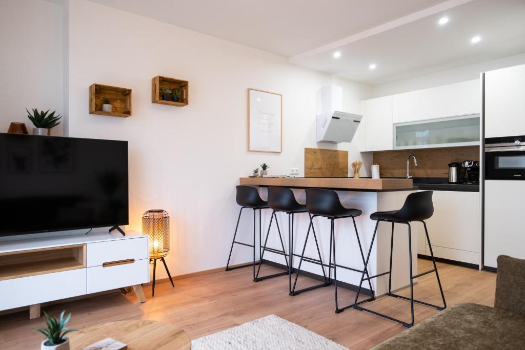 uma sala de estar com uma cozinha e um bar com bancos em MH Living - 23 - Scandinavian Living Dream in Center em Graz