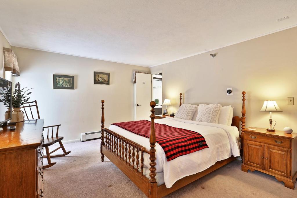 a bedroom with a large bed with a red and white blanket at The Birch Ridge- Colonial Maple Room #1 - Queen Suite in Renovated Killington Lodge home in Killington