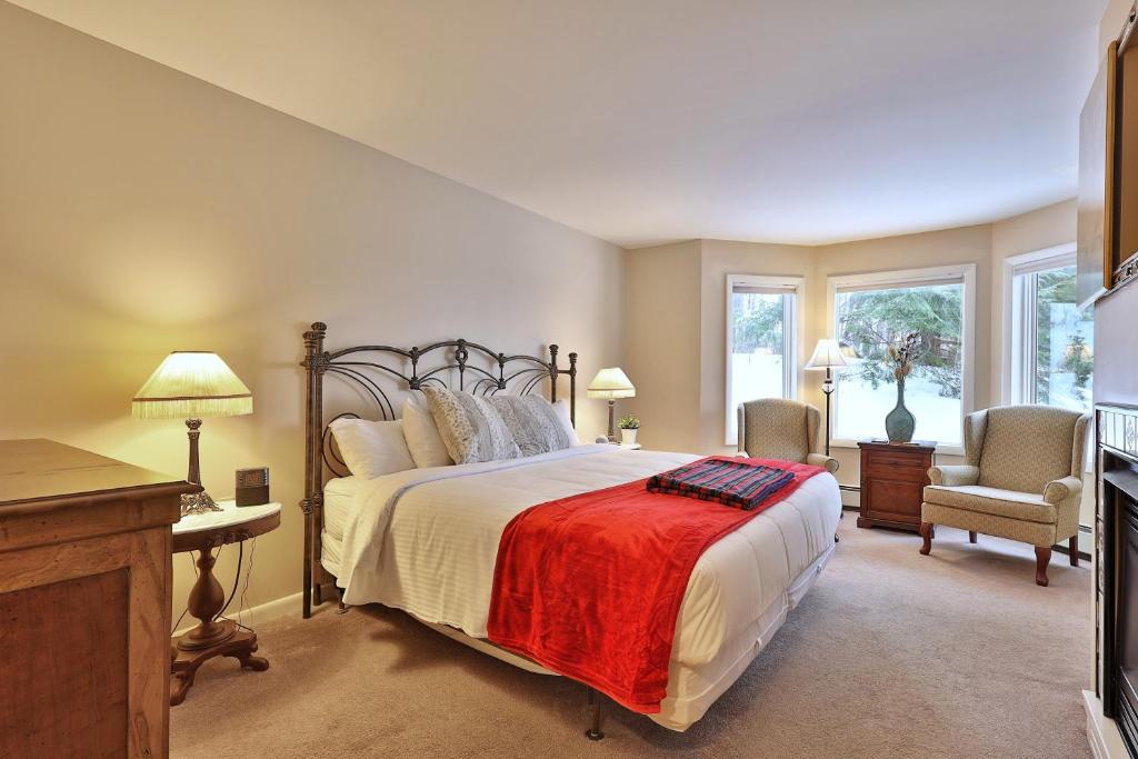um quarto com uma cama grande e um cobertor vermelho em The Birch Ridge- American Classic Room #7 - King Suite in Killington, Hot Tub, home em Killington